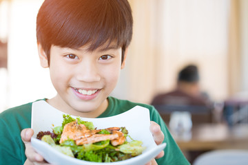 Healthy lifestyle asian child showing salad smiling.