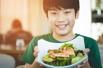Healthy lifestyle asian child showing salad smiling.