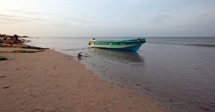 Small fishing boat at twilight sunset on Nilaveli beach in Trincomalee Sri Lanka Asia