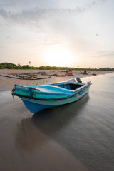 Small fishing boat at sunset on Nilaveli beach in Sri Lanka Asia