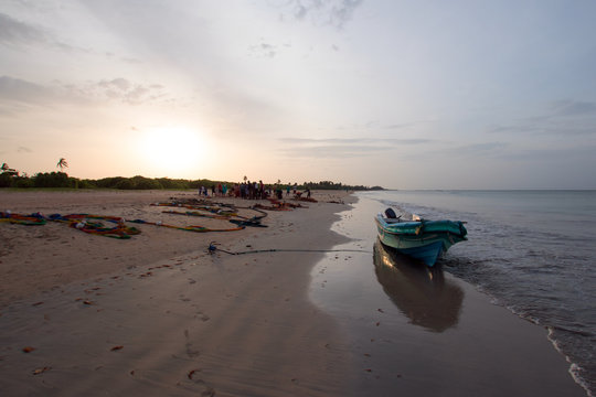 Small fishing boat on shore at sunset on Nilaveli beach in Trincomalee Sri Lanka Asia