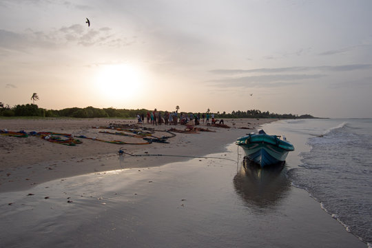 Small fishing boat reflected in sunset light on Nilaveli beach in Trincomalee Sri Lanka Asia