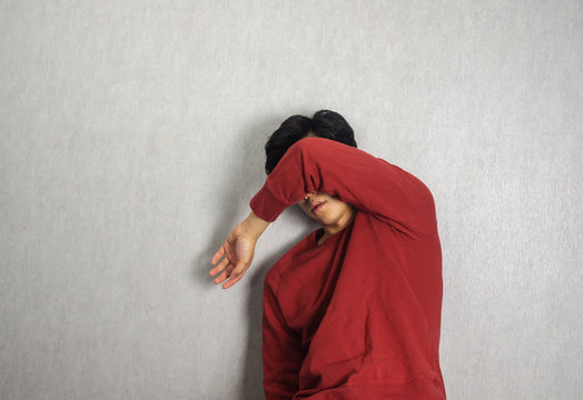 Cover Face By Arm By Man Wearing Red Sweater