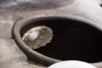 Chapati, Tandoori naan or roti - indian. Baked dough in earthen jar.