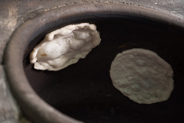 Chapati, Tandoori naan or roti - indian. Baked dough in earthen jar.