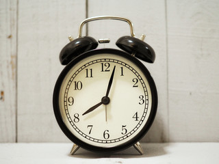 alarm clock on white wooden background