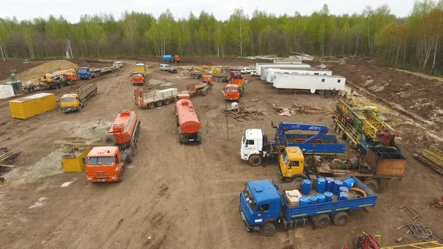 aerial large building site on ground with vehicles trucks cranes at forest