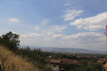 View from the hill to a small town with slate roofs spread out in a mountain valley