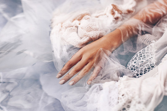 close up of woman hand lying in water with fabric. Fashion concept