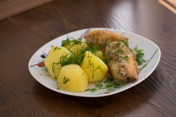 Slices of grilled sea bass with boiled potatoes on the plate.