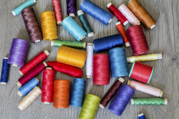 Multi Colored Thread Yarns on Wooden Background 