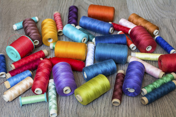 Multi Colored Thread Yarns on Wooden Background 