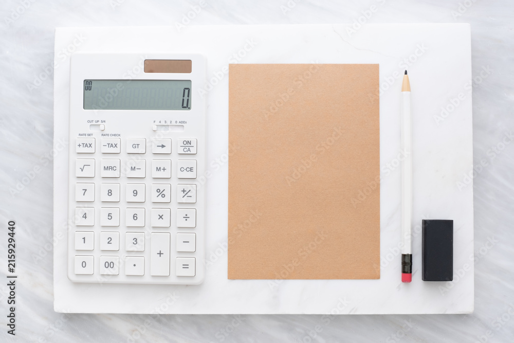 Poster Top view of calculator, pencil, eraser and brown  notepad on white marble block and stack on grey marble table.Flat lay Mock up template for adding or display text or design.Stationery item.