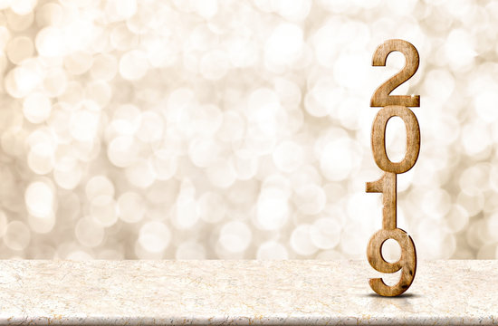 Happy New Year 2019 wood with sparkling star on marble table with gold bokeh background,Holiday festive celebration concept.copy space for display of text or content.