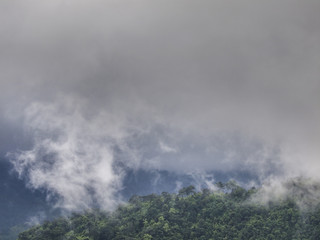 Wild monsoon clouds cover forested mountainous slopes in Kanchanaburi Province, eastern Thailand