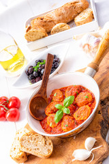 Baked mini meatballs in tomato sauce with basil