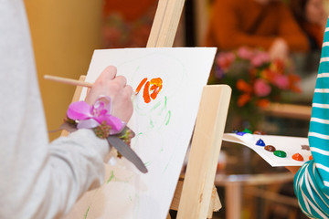 Hand with a brush, painting with oil paints.