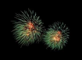 Green and red fireworks explosion on night sky