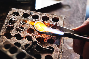 Close up of a goldsmith while he is working to make a diamond ring. Concept: jewelry, silver, gold