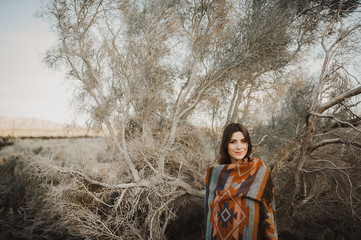 Hipster traveler girl in gypsy look in desert nature.  Artistic photo of young hipster traveler girl in gypsy look, in Coachella Valley in a desert valley in Southern California.