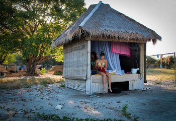 two girls living in a straw hut on kanawa island, Indonesia