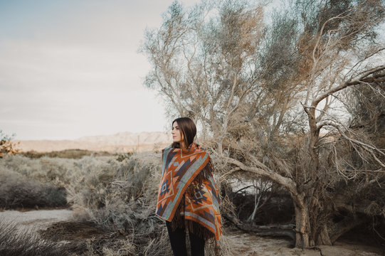 Beautiful hipster traveler girl in gypsy look in desert nature.  Artistic photo of young hipster traveler girl in gypsy look, in Coachella Valley in a desert valley in Southern California.