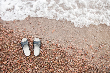 Fototapeta na wymiar Beach slippers in the sand on beach