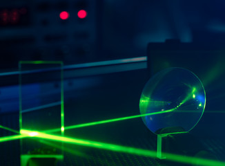 Green laser on optical table in a quantum optics lab.