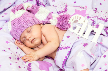 Fototapeta na wymiar portrait newborn baby sweetly a sleep in long gnome hat and a blanket in the stars
