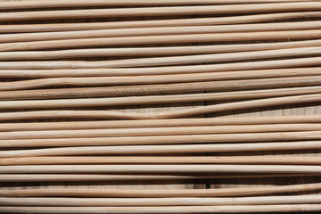 Wooden sticks of non-uniform shapes arranged parallel to each other creating an interesting background.