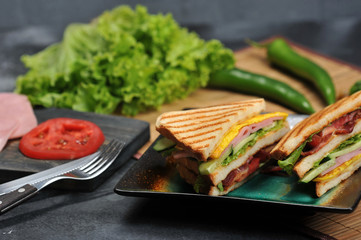 triangular shaped sandwiches with ham and omelet on a plate