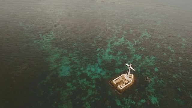 Aerial view Sunken Cemetery cross in Camiguin Island, Philippines. Large crucafix marking the underwater sunken cemetary of the coast of camiguin island near mindanao in the Philippines. Catholic