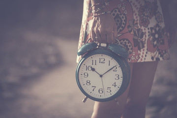 timeless and fairy concept. beautiful caucasian woman take an old big alarm. vintage colors and...