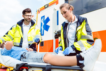Paramedic and emergency doctor caring for injured boy on stretcher