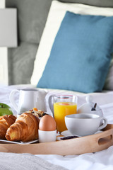 Breakfast on tray in bed in hotel room