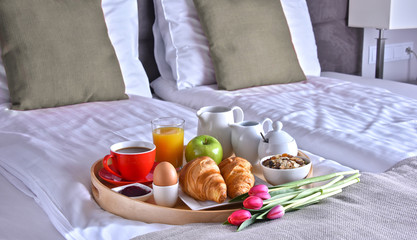 Obraz na płótnie Canvas Breakfast on tray in bed in hotel room