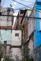 Vertical photo of colourful worn houses of a favela in Brazil.