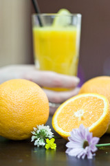 Glasses with fresh orange juice and fruit on table.