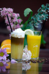 Glasses with fresh orange juice and coffee cocktail on table.