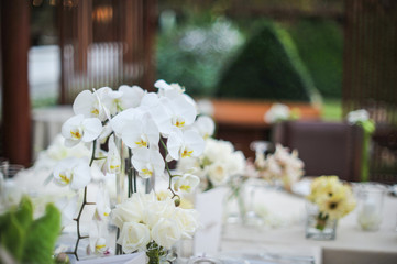 Wedding preparation restaurant and wedding planners.Chairs and honeymooners table decorated with candles, served with cutlery and crockery and covered with a table cloth.