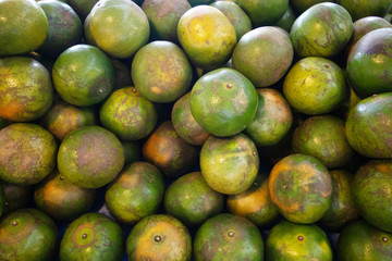 orange type of tropical fresh fruits , heap of organic nutrition diet fruit at asian market in Thailand . common useful vitamin for good foods .