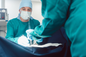 Doctors and surgeons operating patient in hospital with full concentration 