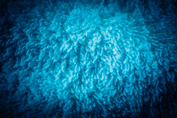 A white bath towel, blue abstract soft texture closeup.