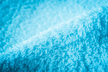 A white bath towel, blue abstract soft texture closeup.