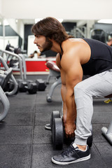 Bodybuilder lifting dumbbell weights in a gym