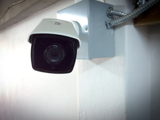 Modern CCTV camera on a wall. Concept of surveillance and monitoring.