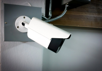 Modern CCTV camera on a wall. Concept of surveillance and monitoring.