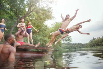 Fototapeta premium Enjoying river party with friends. Group of beautiful happy young people at the river together