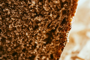 A piece of handmade freshly baked rye bread, texture background, closeup.