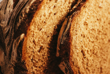 A piece of handmade freshly baked rye bread, texture background, closeup.